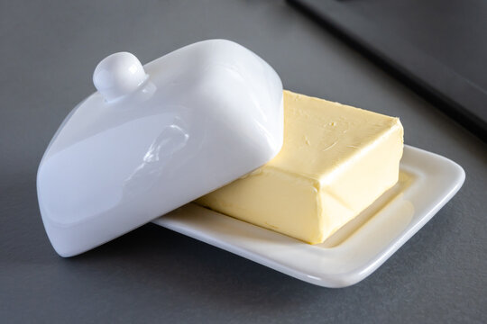 Ceramic block of butter on the gray kitchen table.