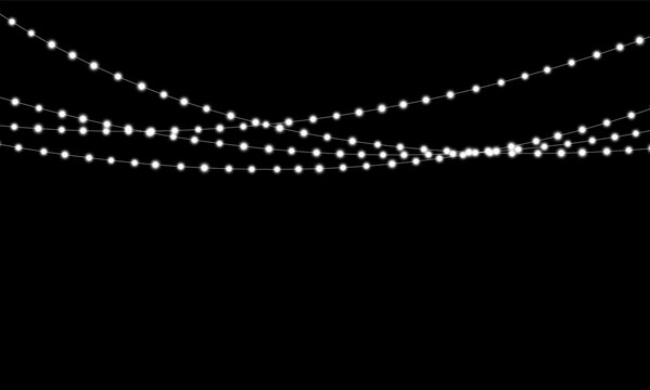 Strings of white glowing lights hang suspended on black background. The lights are evenly spaced and emit a soft, radiant glow. This setup is ideal for festive decoration or atmospheric.