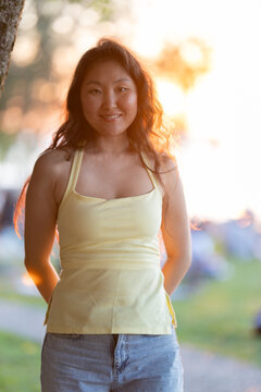 Young asian woman smiling outdoor during sunset golden hour