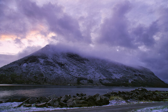 Violet Evening Sky Over Snow-Covered Mountain at Fjord.
