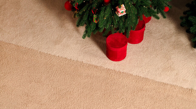 Festive Christmas tree with red gift boxes on a textured carpet for holiday season advertising background empty copy space