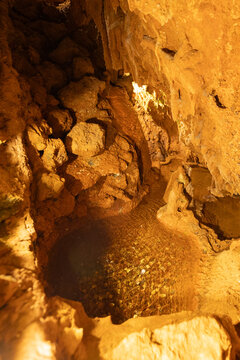 Rocky cave with water pool and illuminated walls in a natural setting