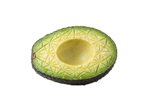 Carved avocado half with intricate geometric art pattern, fresh green carved fruit isolated on white background, creative culinary food decoration