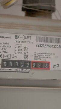 Vertical Screen: A gas meter in use. It displays current readings and shows how gas flow measurements are taken in a residential setting for billing.