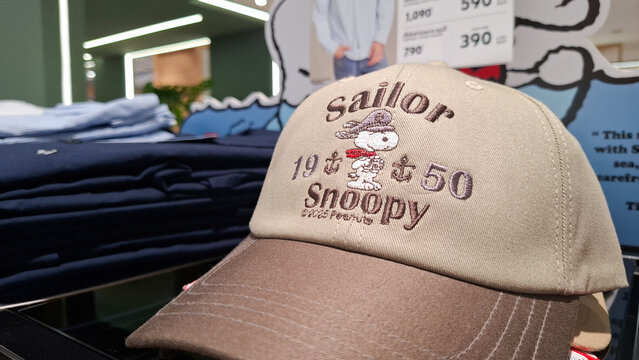 Beige and brown embroidered sailor snoopy gq baseball cap display in retail store close up view on September 23, 2026 in Bangkok, Thailand 
