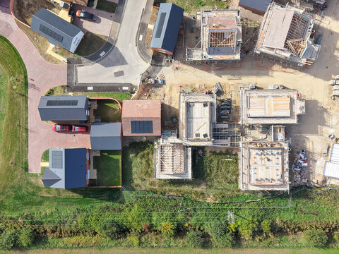 Interesting drone top down view of a partially completed, large housing development in the UK. Showing both built and partially built detached homes.