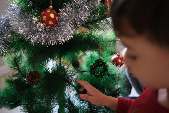 Children decorating christmas tree with ornaments for holiday season