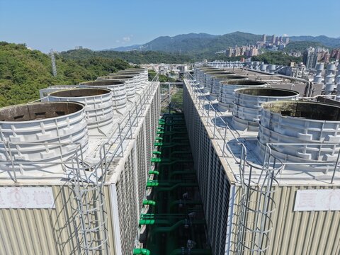 Industrial cooling towers array on rooftop of modern data center building.