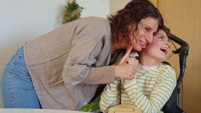 Loving mother interacting with her disabled son in wheelchair
