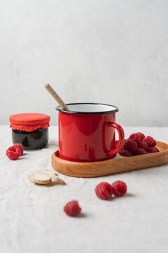 Red enamel mug with a warm drink on a linen tablecloth, cozy rustic kitchen still life and homemade beverage concept