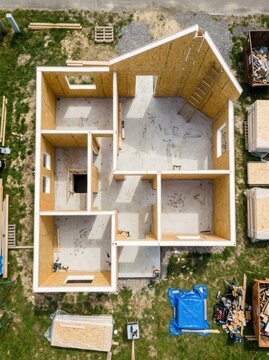 Aerial Top View of a Modern House Under Construction with SIP Panels and Concrete Foundation on a Building Site