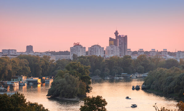 8 August 2026, Belgrade, Serbia: skyline at sunset, showing the Genex Tower, urban buildings, and boats navigating the calm Sava river
