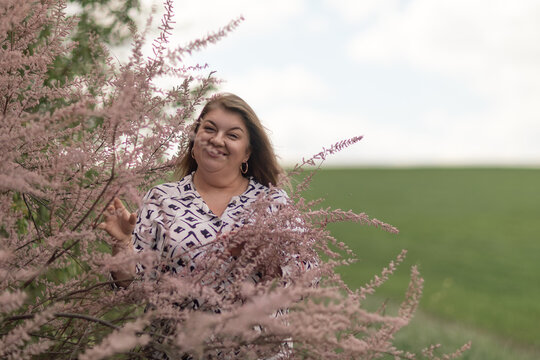 Woman smiling tamarix bush green field copy space