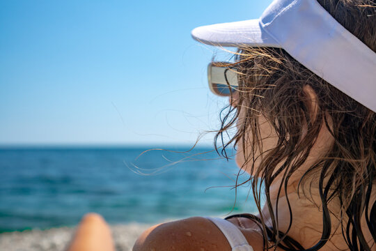 Sun visor on woman looking at sea during summer vacation
