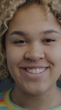 Portrait of attractive African American woman smiling looking at camera on black background. Real people and positive emotion concept.