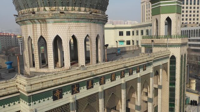 Rising drone flight of Dongguan mosque towards modern cityscape of Xining in China