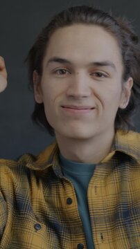 Portrait of joyful young man dancing looking at camera on black color background. Entertainment and positive emotion concept.