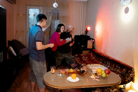 Happy Family and Friends Having Fun Singing Karaoke at Home Party