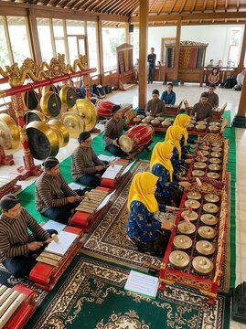 Traditional Javanese Gamelan Orchestra Performance with Musicians in Ethnic Attire Playing Bronze Percussion