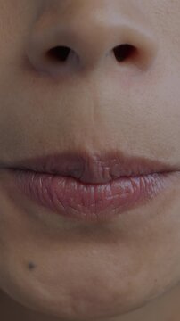 Close-up of female mouth grimacing while nervous young woman pursing lips. Negative emotion and face expressing concept.