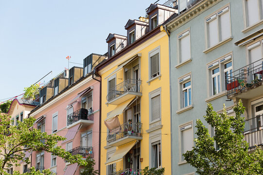 Row of pastel colored apartment buildings with awnings and balconies in Zurich, Switzerland