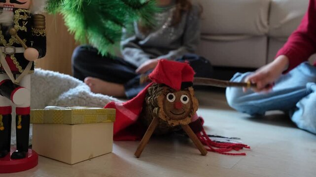 Children hitting the traditional caga tio christmas log