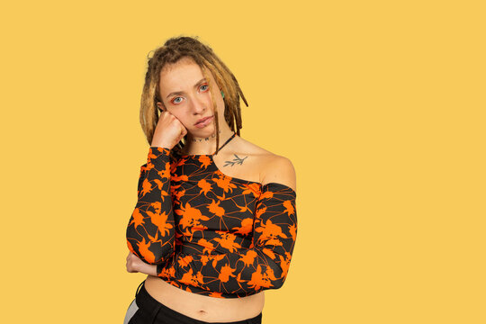 Young woman feeling bored and apathetic on yellow background