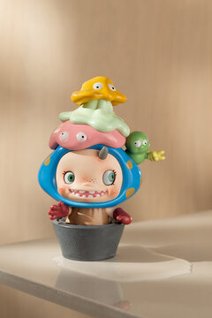 A POLAR HELLO POLAR Season 1 art toy is displayed in a pot with several colorful creature figures on a platform.
