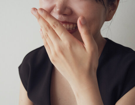 Smiling Woman Covering Face With Hand