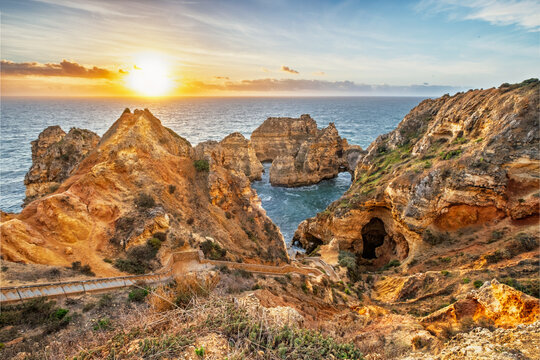 Ponta da Piedade sunrise in Lagos, Algarve, Portugal, with ocean cliffs, sea stacks, walking path, and bright Atlantic morning light
