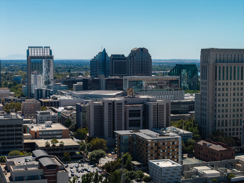 Aerial view of downtown Sacramento in California, featuring corporate skyscrapers, commercial office towers, civic architecture, and streets under clear sky.