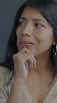 Portrait of creative Hispanic woman thinking raising finger having idea on black background. Problem solving and people concept.