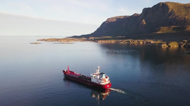 Aerial view rising away from a tanker moving in a fjord landscape of Greenland