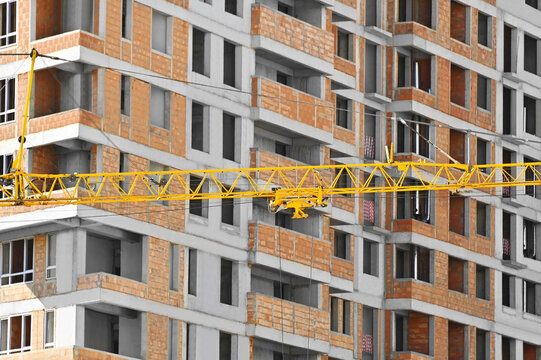 Yellow crane winch against building under construction