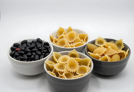 Healthy nutrition and balanced diet, raw black beans and dry pasta in ceramic bowls for cooking preparation and meal planning on a white background