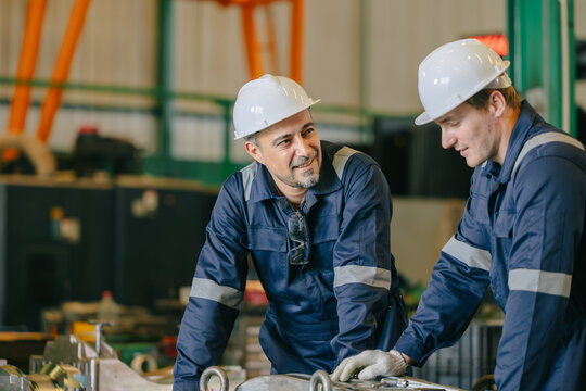 Professional engineer team worker training young man to service injection mold in die casting plant