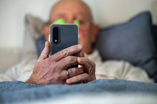 Stockholm, Sweden A man lays in bed with a cell phone.