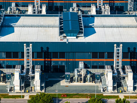 Aerial view of the Agriport a7 industrial facility with modern architecture, large HVAC cooling units, and complex piping systems, Middenmeer, Noord-Holland, Netherlands.