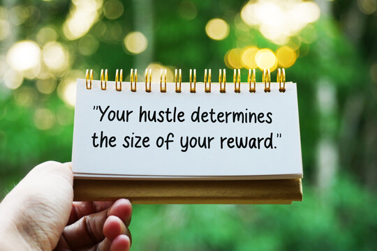 Hand holding a notepad with text Your hustle determines the size of your reward outdoors.