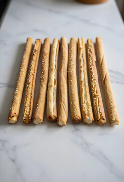 Appetizer and catering concept, crispy breadsticks with cheese filling arranged in a row on a white marble surface for restaurant menu and food blog