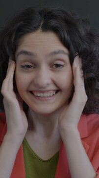 Slow motion portrait of excited young woman expressing joy on black background. Positive emotion and surprised person concept.