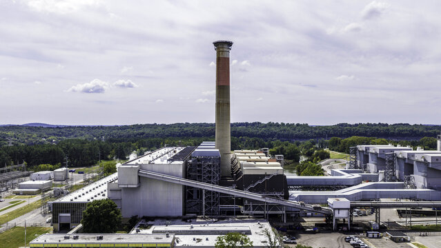Aerial view of the Gallatin Fossil Plant coal-fired power station featuring a prominent exhaust stack and industrial infrastructure surrounded by lush greenery in Gallatin, TN, United States.