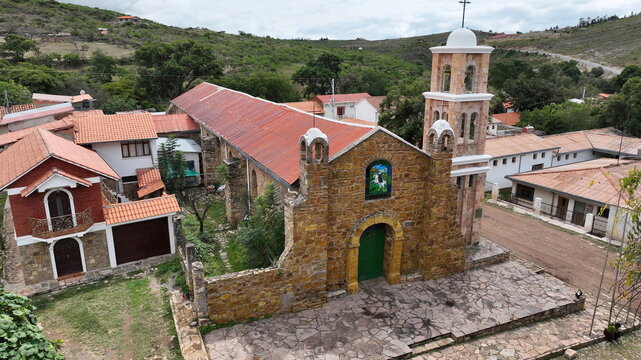 Aerial view of the historic stone church in Torotoro with its distinctive bell tower, red tiled roofs, and surrounding village buildings in Torotoro, Potosi Department, Bolivia.