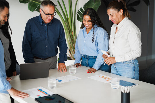 Multigenerational business people sharing ideas inside company office - Brainstorming and corporate concept - Main focus on african girl face - UGC content