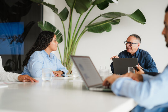 Business people sharing ideas at teamwork meeting inside creative office - Multiracial colleagues discussing new project - Brainstorming and corporate concept - Main focus on man face - UGC content