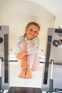 Young girl relaxing in cozy spot on sailing yacht during family vacation. Life aboard gives children playful moments, comfort and memorable experience at sea