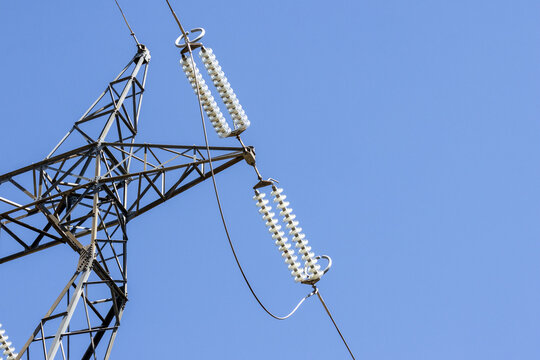 Electricity pylon transmitting power lines against blue sky