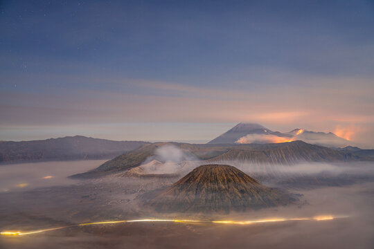 Sunrise at Mount Bromo, Volcanic peaks rise above a blanket of mist at sunrise near Mount Bromo in East Java, Indonesia.