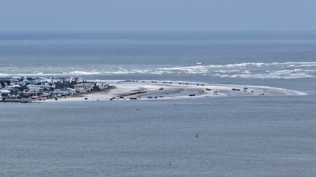 Aerial view of the coastline and sandy beach with residential houses and vehicles parked along the shore in St. Augustine, Florida, United States.