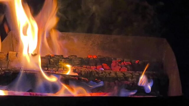 Campfire burning in the dark during a night in the wilderness, camping and outdoor adventure concept